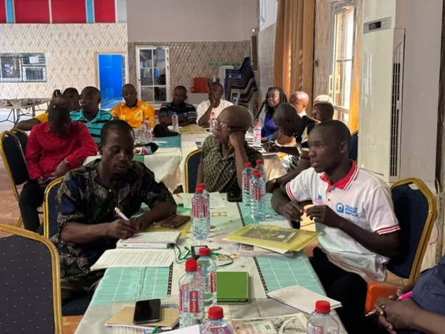 People hearing a speech and taking notes