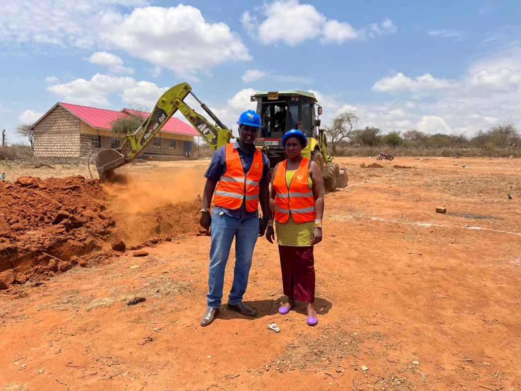 Two construction workers pose for a picture