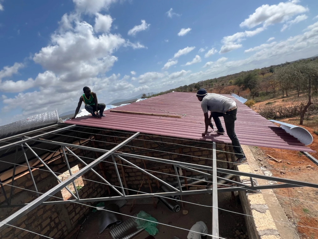 Two workers build a roof