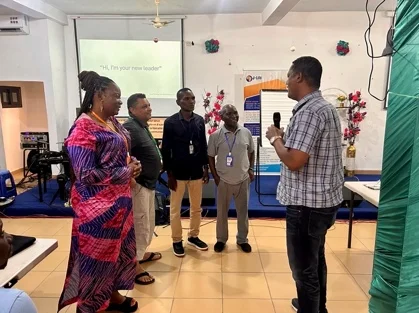 A small group of DMM leaders engaged in face-to-face discussion during an interactive exercise at the Leadership Challenge Summit in Lomé, Togo, with a presentation screen visible in the background