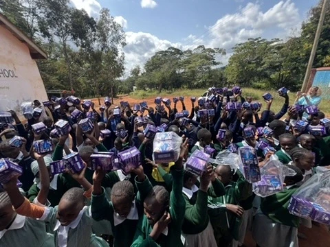 Different school girls receiving dignity pads at their respective schools in Kenya