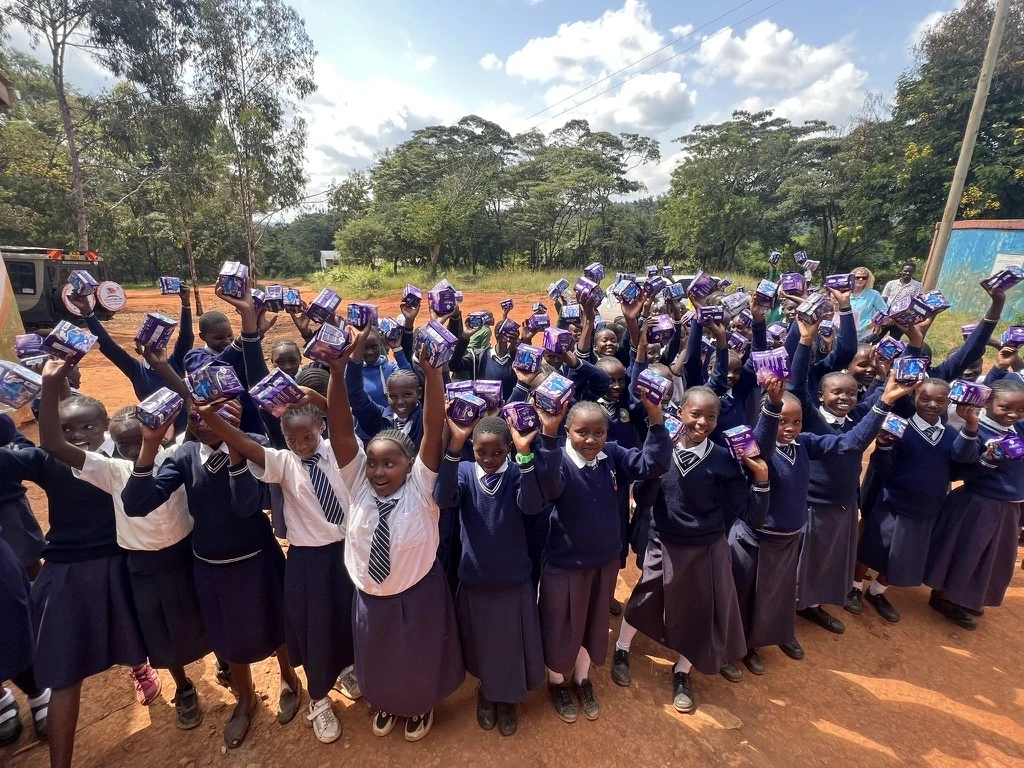 Different school girls receiving dignity pads at their respective schools in Kenya